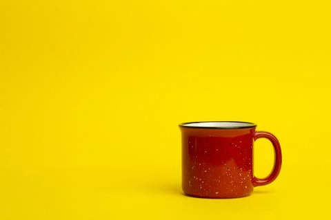 Red ceramic cup on a yellow background. Vintage and retro cup and dishes Stock Photos