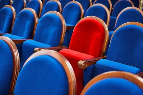 Red chair among the blue seats. Special or VIP seat in the meeting room Stock Photos