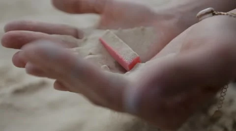 Red chalk with sand wakes up through the palm Stock Footage 45173508
