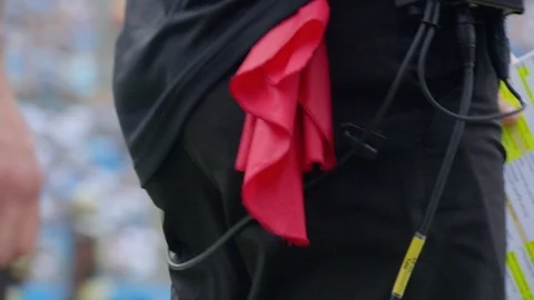 Red challenge flag in coaches pocket during American football game Video stock 104770412