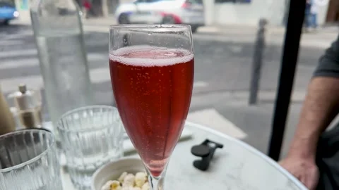 Red Champagne Cocktail on Marble Table at Outdoor Paris Sidewalk Cafe Stock Footage 335856525