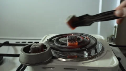 Red charcoal for hookahs, cooked on an electric stove Stock Footage 255228520