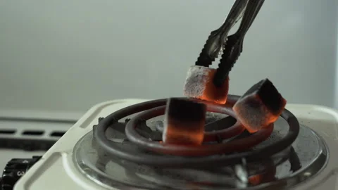 Red charcoal for hookahs, turned over on an electric stove Stock Footage 255562622