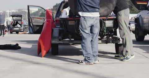 Red Chargers taking down rescue sled with jet ski from car parked in port Video stock 163074239