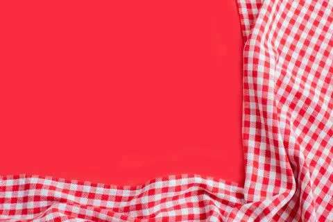 Red checkered tablecloth on a red background. Stock Photos