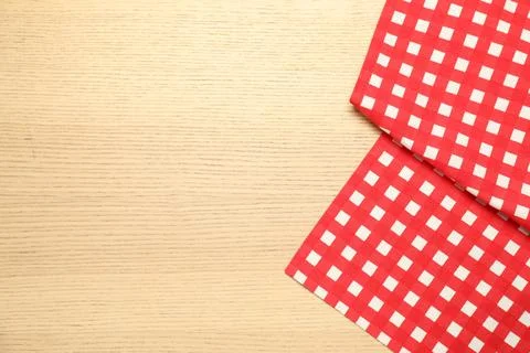 Red checkered tablecloth on wooden background, top view. Space for text Stock Photos