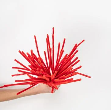 Red chenille wire on a light background. A lot of material for needlework in  Stock Photos