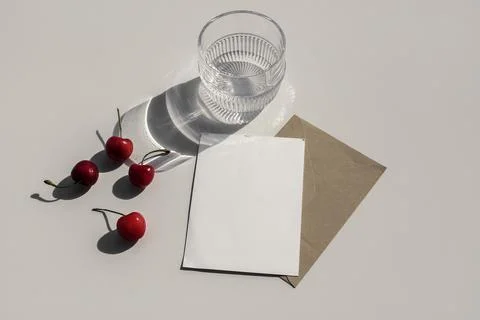 Red cherries fruit on beige table background. Stationery mock up. Blank greeting Foto stock