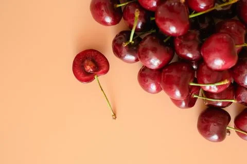 Red cherries on peach background Stock Photos
