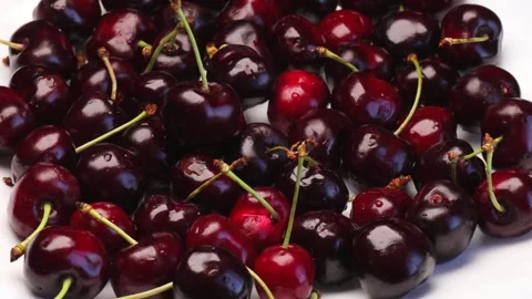Red cherries rotating slowly on white table in bright natural light juicy shiny Stock Footage 312002731