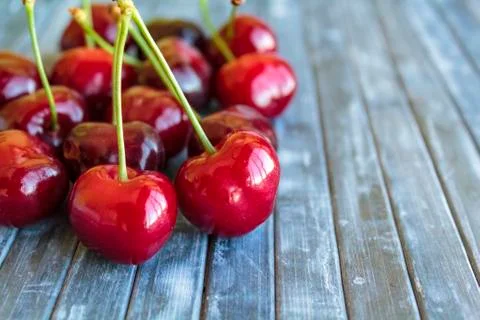 Red cherries on rustic background Stock Photos