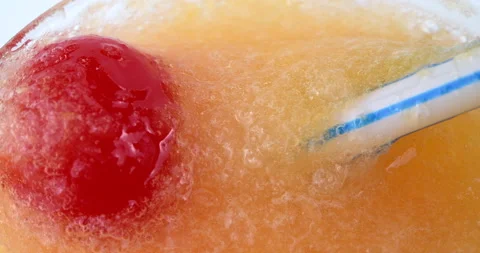 Red cherry garnishing an orange flavored daiquiri Stock Footage 148946455