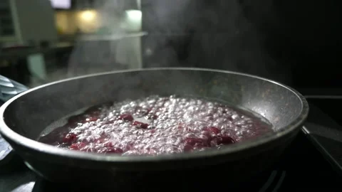 Red cherry mixed with sugar cooking on a frying pan in a restaurant kitchen Video stock 135218910