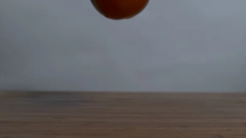 Red cherry tomato falling and bouncing on wooden surface Stock Footage 100006198