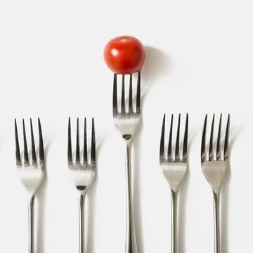 Red cherry tomato fork against white background Stock Photos