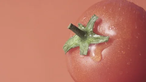 Red cherry tomato with green tail,  spray water goes down, ungraded clip Stock Footage 102570153