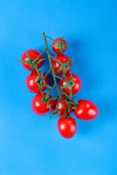 Red cherry tomatoes on blue Stock Photos