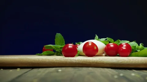 Red cherry tomatoes fall down onto wooden table slow motion Stock Footage 120166757