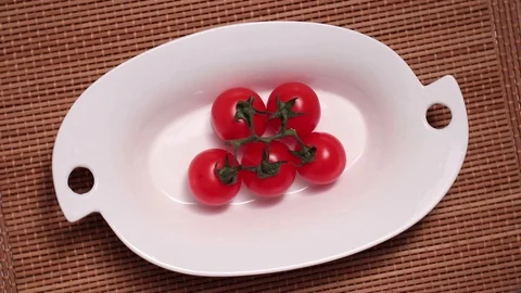 Red cherry tomatoes in small plate on rotating Stock Footage 127573772