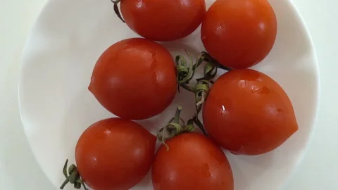 Red cherry tomatoes on a white plate rotate. Stock Footage 133394528