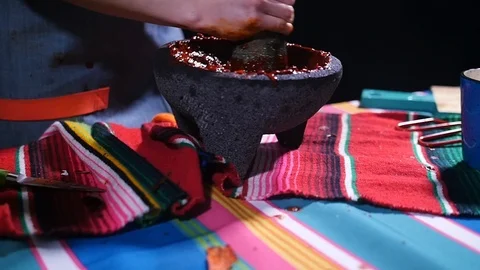 Red chile salsa being made in Mexican volcanic rock mortar. Stock-Footage 105295740