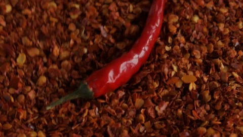 Red Chili Pepper Falling onto a Pile of Chili Granulate High Angle Stock Footage 99138469
