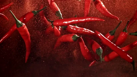 Red chili pepper in flight with ground pepper. Filmed on a high-speed camera at Stock Footage 307992468