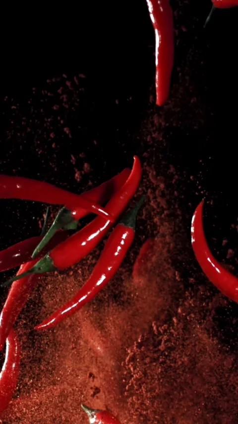 Red chili peppers fly up and fall down. Filmed on a high-speed camera at 1000 動画素材 335367237