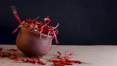 Red chilli falling on a mud pot Stock Footage 212788410