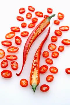 A red chilli, halved surrounded by chilli rings Stock Photos