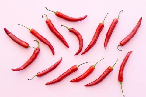 Red chilli pepper on a pink background, vegetable pattern. Pattern of food... Stock Photos