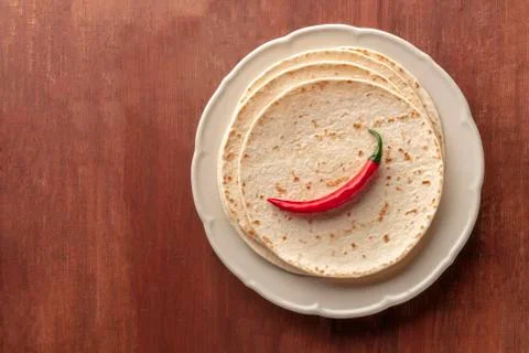 A red chilli pepper, shot from the top on a pile of tortillas, Mexican 写真素材