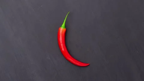 Red chilli peppers over grey concrete background. Spicy food ingredients. Stock Footage 168902964