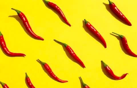Red chilli peppers pattern on yellow background. Top view. Hot pepper flat lay. Stock Photos