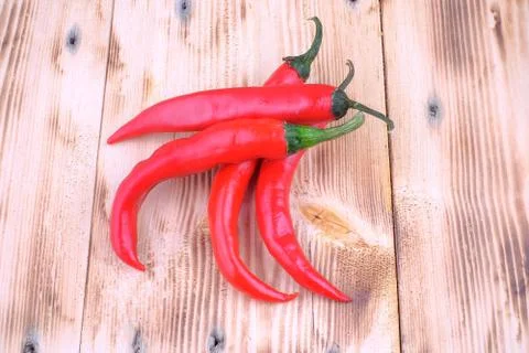 Red chilli on wood pine table Stock Photos