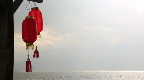 Red chineses lanterns swaying in wind against beautiful Erhai lake in Dali Stock Footage 51724042