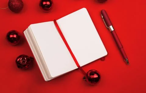 Red Christmas decor, Notepad planner with pen on red background. Copy space.  Stock Photos