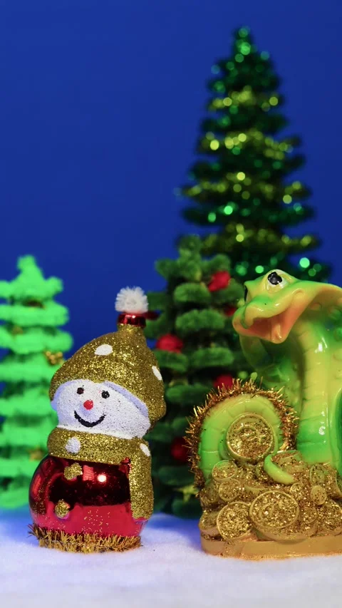 Red Christmas house surrounded by two snowmen and a snake figurine Stock Footage 299271683