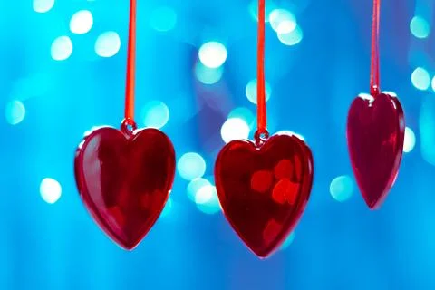 Red Christmas tree decorations in the shape of a heart on a blue background of Photos