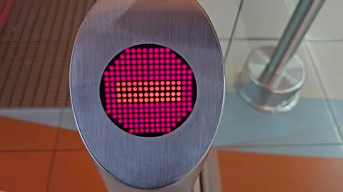 A red, circular display on a silver turnstile shows a pixelated patter Stock-Footage 312003047