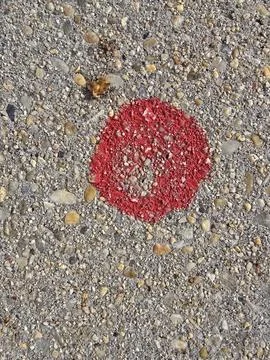 Red Circular Marking on Rough Concrete Surface Stock Photos