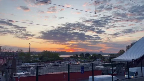 The red city sunset is interrupted by a moving train. - stock video Stock Footage 240342875