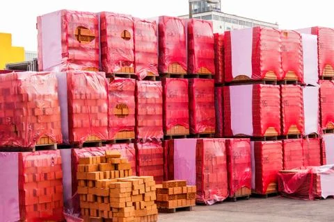 Red clay bricks stacked on pallets Stock Photos
