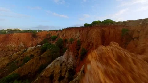 Red clay cliffs meet calm beach as drone flies low Video stock 346091230