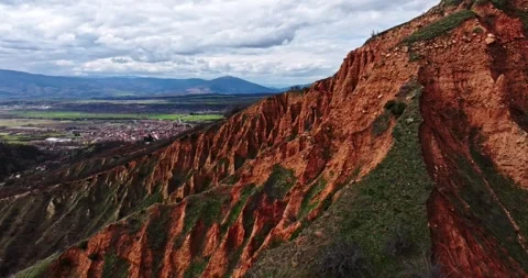 Red Clay Ridge Overlooking A Small Town Drone Steady Zoom Shot Parallax Stock Footage 289409457