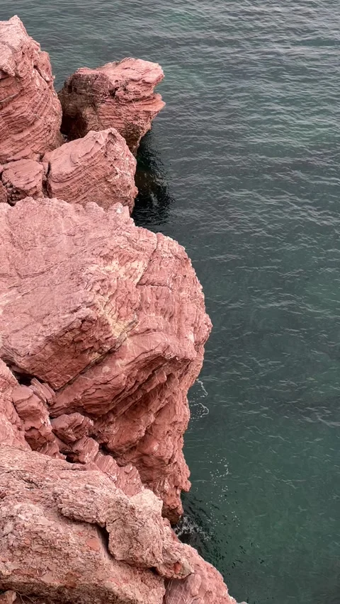 The red cliffs of the cliff rise above the green water Stock Footage 251008796