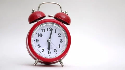 Red clock alarm clock rings on a light background Stock Footage 221473884
