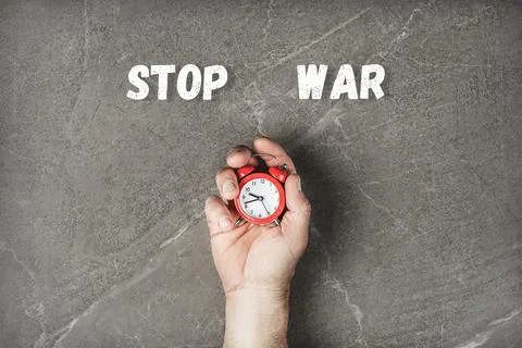 Red clock in hands on gray background Stock Photos