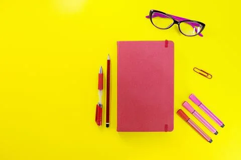 Red closed diary, notebook with pen, pencil, marker and glasses Stock Photos