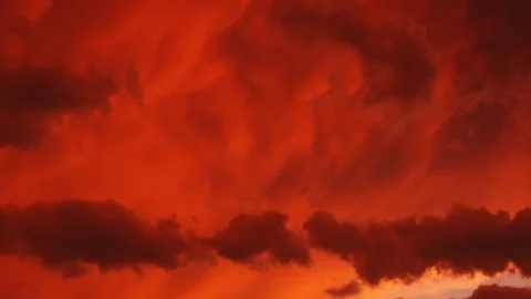 Red clouds behind other clouds, some blue, evening storm brewing ? Video stock 301462933